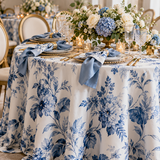 Luxury wedding tablescape featuring bespoke blue floral tablecloth, coordinating fabric napkins and elegant gold table settings by Charissine Creations.